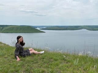 person sitting on the edge of lake. person sitting on a rock. 