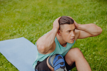 Man doing abs exercise on grass in a park