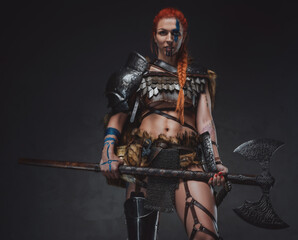 Charming woman viking holding an axe in dark background