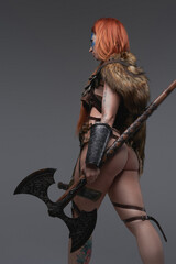 Redhead sexy woman warrior from north with axe in gray background