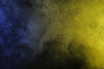 Artificial magic smoke in blue yellow light on black background