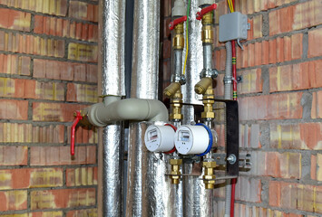Water meter of cold and hot water on the brick wall background in new flat. Devices for measuring the amount of consumed water