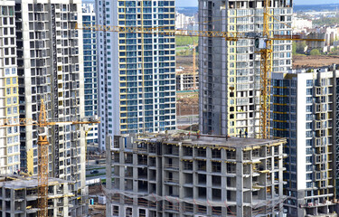 Fototapeta na wymiar Tower crane during construction of a residential building. Cranes on formworks. Construction the building or multi-storey homes, Arial view. Renovation concept. Realtor and Real Estate