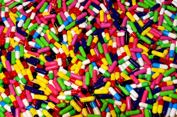 Multicolored pills in capsules. Pharmaceutical pills background, medical tablets and capsules. Medical pill for maintaining and improving health. Concept of healthcare and medicine