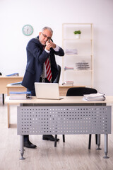 Old businessman employee holding riffle in the office