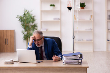 Old male employee in blood transfusion concept