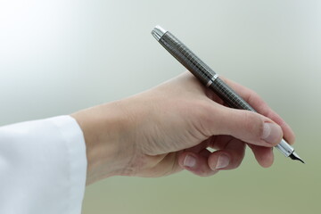 Doctor's hand holding a fountain pen. Close up