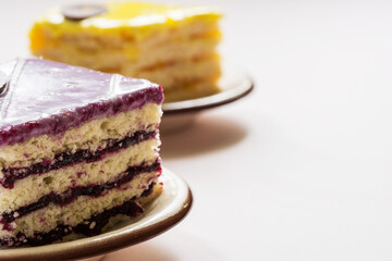 Close-up of a piece of a berry cake. Lemon cake in the background.