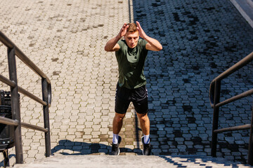 Young man athlete training on a stadium. Jumping upstairs on staircase and warming up before run....