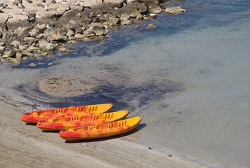 Three kayaks stranded on the shore of the beach. Sports and holidays concept