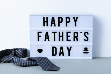 Happy father's day inscription on the lightbox with striped tie, happy father's day concept idea. 