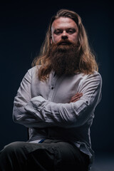 Close up portrait of handsome manly guy with beard posing in studio on a isolated background.