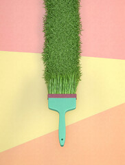 Ecological concept .of paint brush that leaves behind fresh green grass. Creative eco program on...
