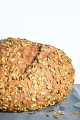 Multigrain bread on a gray cloth and white background. Copy space.