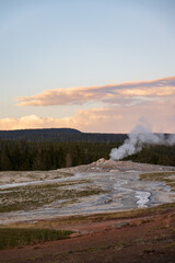 Geyser erupting during sunset at Yellowstone National Park, Wyoming, USA