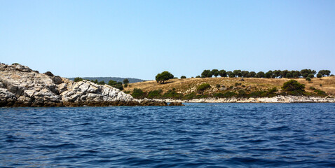 Fototapeta na wymiar A sea coast somewhere in the region of Chalkidiki, Greece as seen from a boat. Shot in the year 2011.