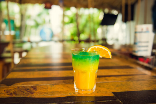 Colorful tropical cocktails on wooden bar. Mixology in pool holiday setting. Caribbean cocktails. Colorful cocktails in caribbean bar hotel.