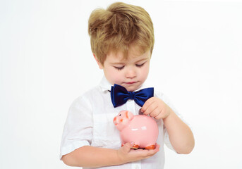 Fototapeta na wymiar Little boy put coin in piggy bank. Saving money concept. Finance. Child with moneybox. Bank advertising.