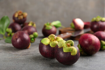 Fresh ripe mangosteen fruits on grey table