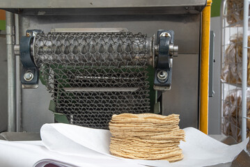machine to make tortillas Mexican tortilleria with metal band and a kilo of tortillas wrapped in...