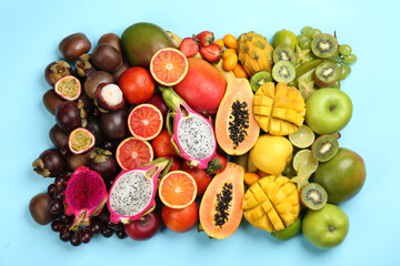 Many different delicious exotic fruits on light blue background, flat lay
