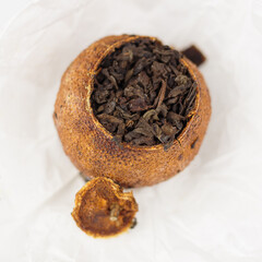 pu-erh tea in tangerine on paper top view isolated