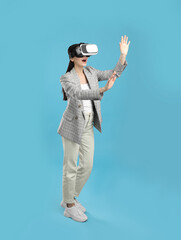 Woman using virtual reality headset on light blue background