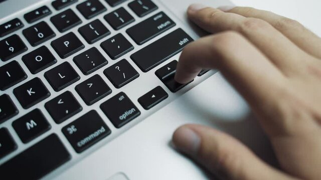 Man with the fingers of his hand using the arrows on the laptop keyboard selects which option is best solution. And after he makes a decision, click enter or return button