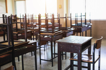 Empty school classroom with desks and chair iron wood for studying. Impact on studies of COVID-19 epidemic