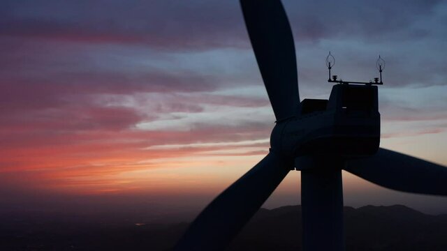 일몰 시간의 높은 산 위 대형 풍력발전기 