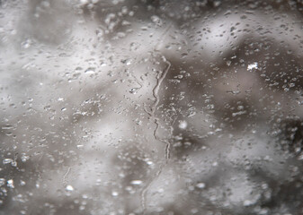 Abstract blurred background. Car glass with water drops from melting snow.