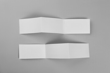 Blank paper brochures on light grey background, flat lay. Mockup for design