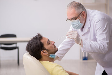 Young male patient visiting old male doctor otorhinolaryngologis