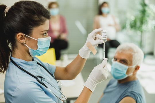 Nurse Holding Coronavirus Vaccine and Syringe