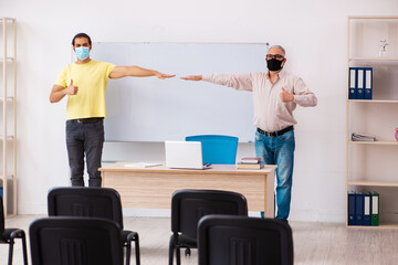 Young male student and experienced teacher in pandemic concept