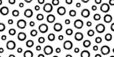 Black and white seamless pattern with rings in brush stroke technique. Abstract background with hand painted circles.