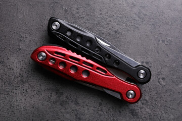 Modern compact portable multitool on grey table, top view