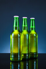 green beer bottle with drops on blue background