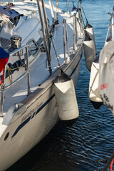 The side of a yacht with mooring fenders next to another yacht. Tight mooring of yachts in the...