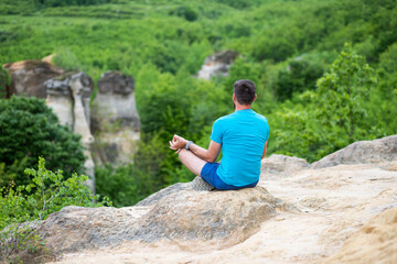 man with his dog sitting on a rock enjoying nature