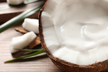 Ripe coconut with cream on table, closeup