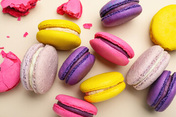 Delicious colorful macarons on beige background, flat lay