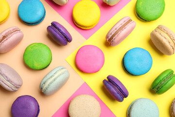 Different delicious fresh macarons on color background, flat lay