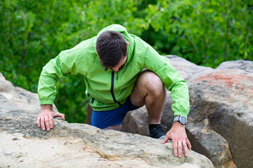man climbing rocks in summer