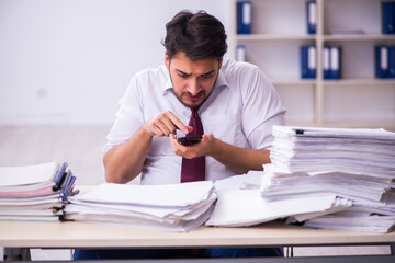 Young businessman employee unhappy with excessive work in the office