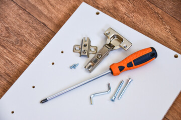 Assembly of cabinet furniture. screwdriver, screws, furniture fittings, door hinges. self-assembly...