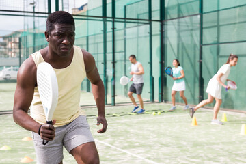 Portrait of young adult man paddle tennis player preparing to game at court during group training