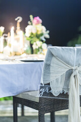 Fototapeta na wymiar Romantic Wedding Table Top Layout Table Spread no people tropical location with gold cutlery at night evening event