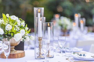 Obraz na płótnie Canvas Romantic Wedding Table Top Layout Table Spread no people tropical location with gold cutlery white table cloth and scenic view of sunset with copy space tablescape, beautiful paradise setting