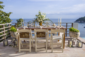 Romantic Wedding Table Top Layout Table Spread no people tropical location with gold cutlery and scenic sea view with copy space
